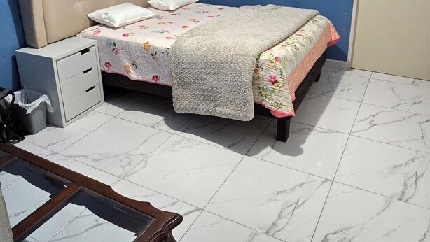 A bedroom with a bed, a bedside table, a wardrobe, and a desk.