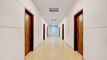 A long, narrow hallway with doors on both sides, leading to individual rooms.