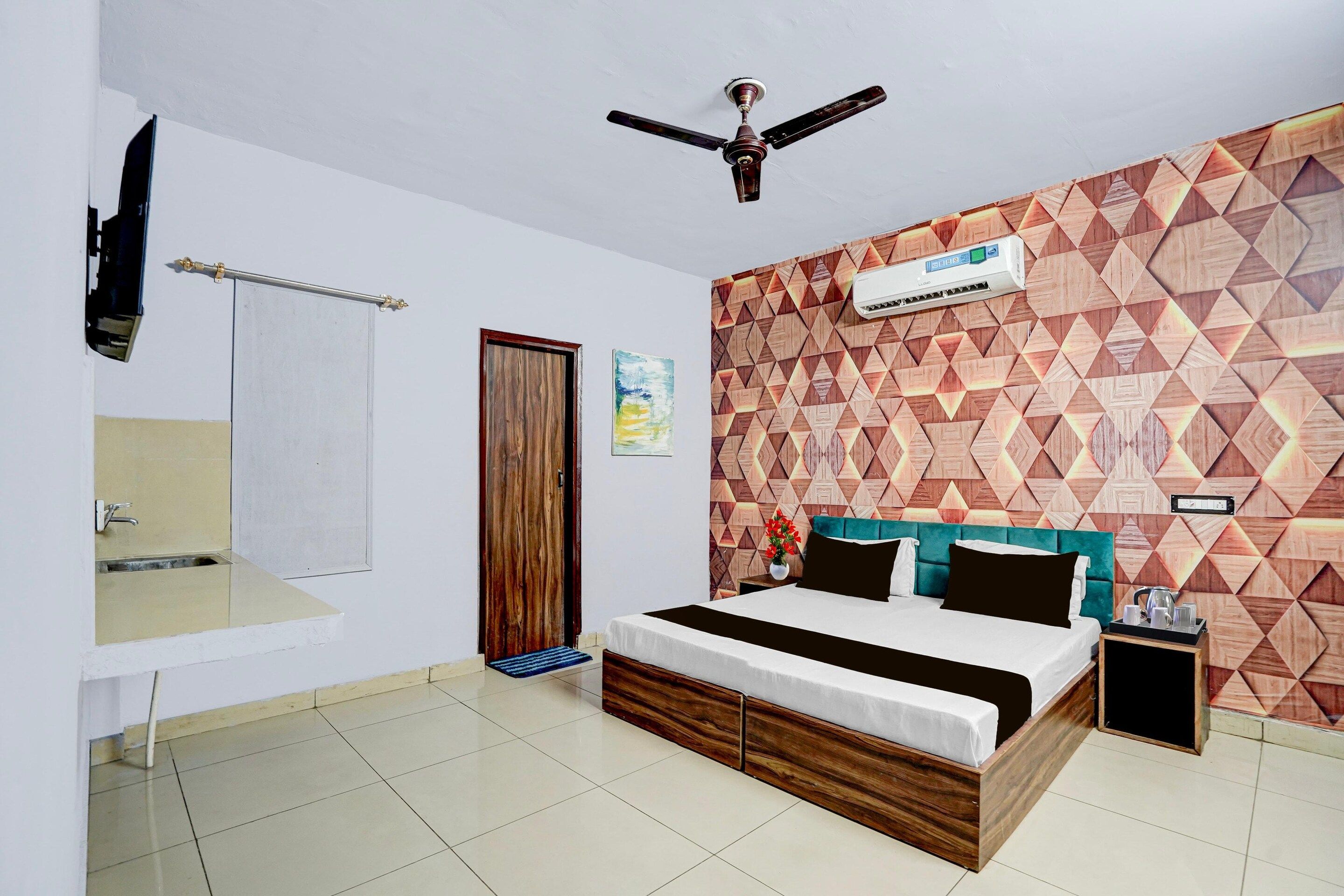 A bedroom with a bed, a ceiling fan, a wall-mounted air conditioner, and a patterned wall.