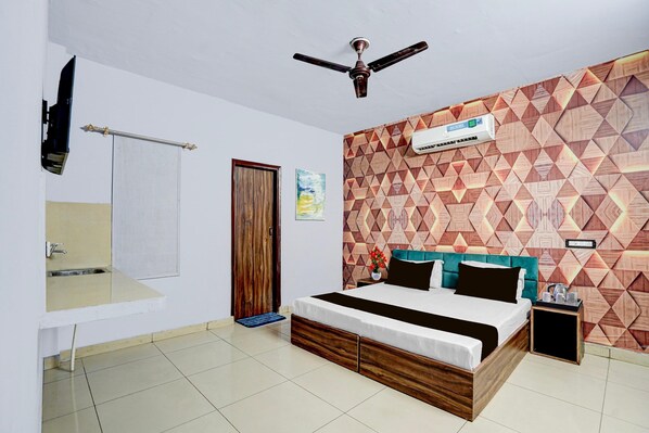 Un dormitorio con cama, ventilador de techo, aire acondicionado en la pared y un papel tapiz estampado.