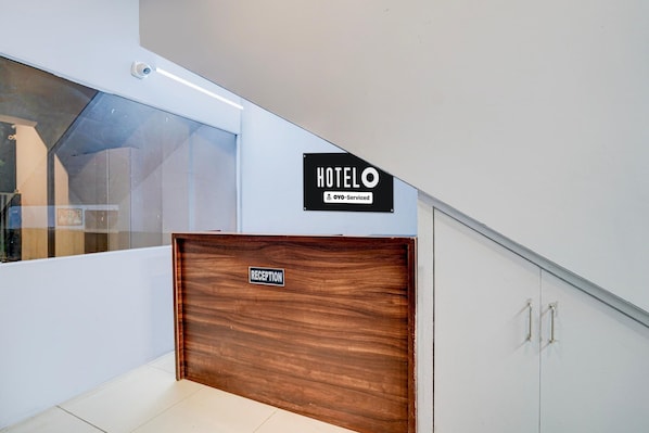A reception desk with a sign indicating it's serviced by OYO.