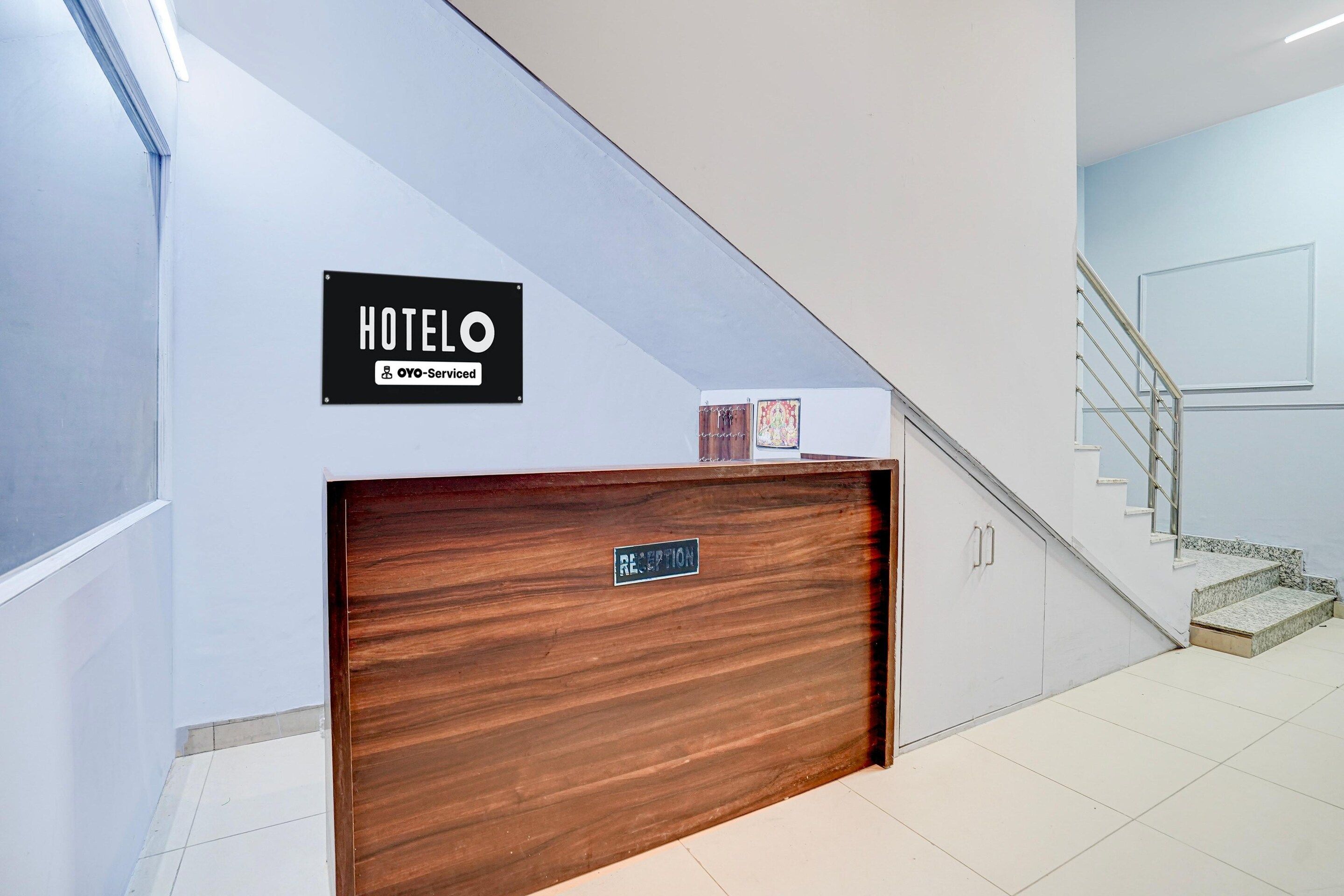 A hotel reception desk with a sign indicating it is serviced by OYO.