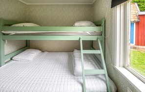 A bunk bed with a ladder, a window with a view of a red building, and a patterned wall. - 2 bedroom lovely home in Ljungbyholm (Ljungbyholm)