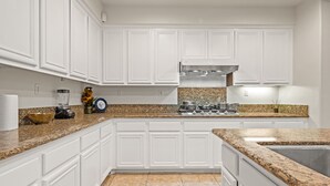 A kitchen with white cabinetry, granite countertops, a stainless steel stove, and a granite backsplash. - Luxury 7BR Getaway/10 Beds/Near Victoria Gardens (Rancho Cucamonga)