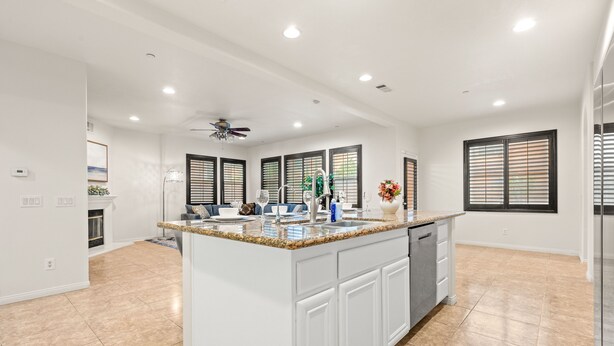 A spacious kitchen with a large island, white cabinetry, and a ceiling fan. - Luxury 7BR Getaway/10 Beds/Near Victoria Gardens (Rancho Cucamonga)