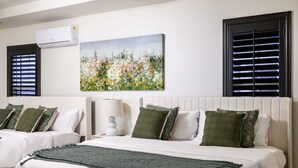 A hotel room with two beds, a painting, and two windows with blinds. - Luxury 7BR Getaway/10 Beds/Near Victoria Gardens (Rancho Cucamonga)
