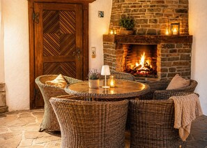 A cozy outdoor seating area with wicker furniture and a stone fireplace. - Villa Ardoise (Brodenbach)