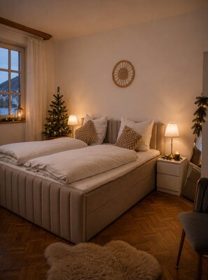 A bedroom with a double bed, two bedside tables, a small Christmas tree, and a wall decoration. - Villa Ardoise (Brodenbach)
