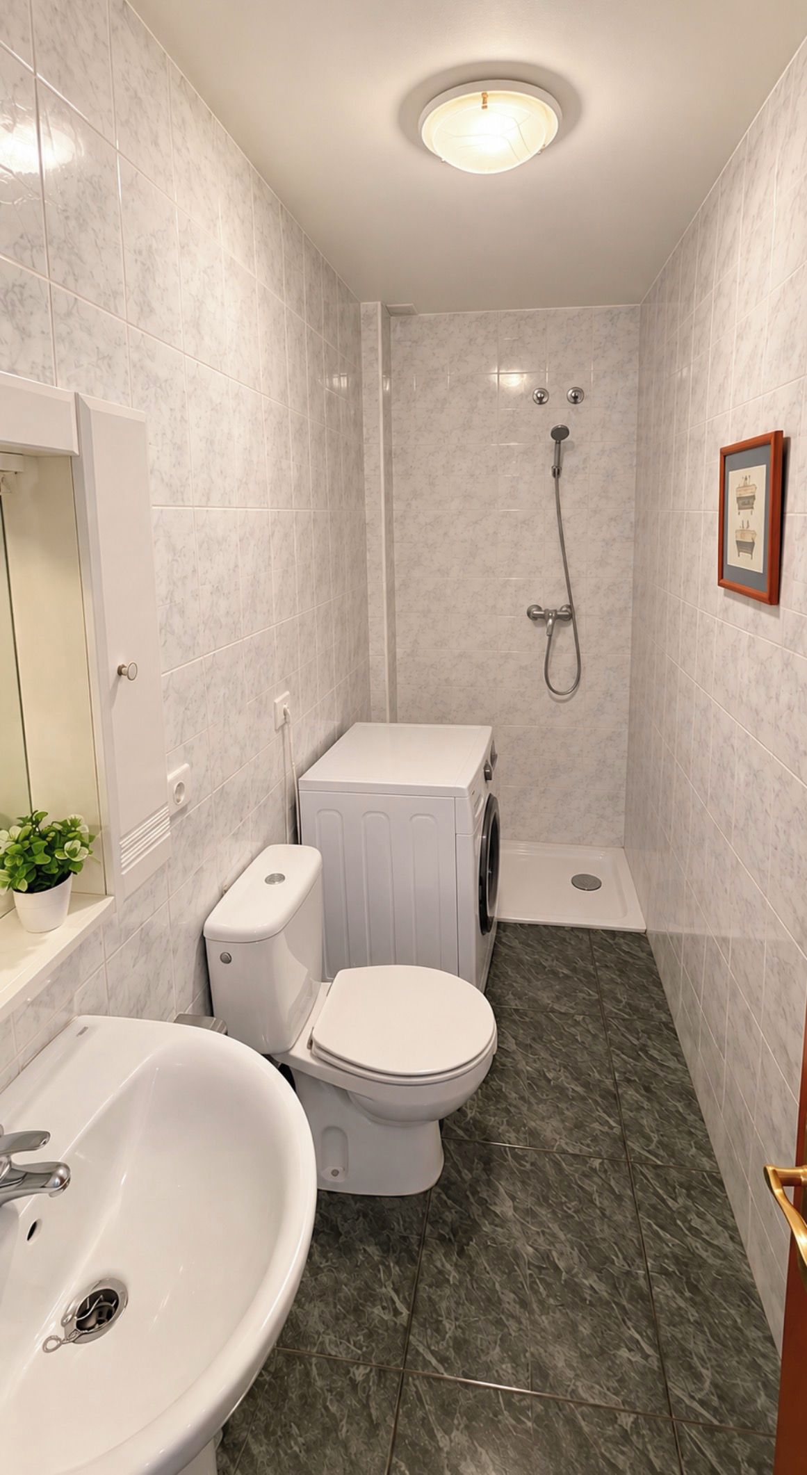 A compact bathroom with a toilet, sink, and shower.