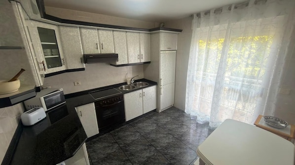 Una cocina compacta con estufa, lavamanos y armarios.