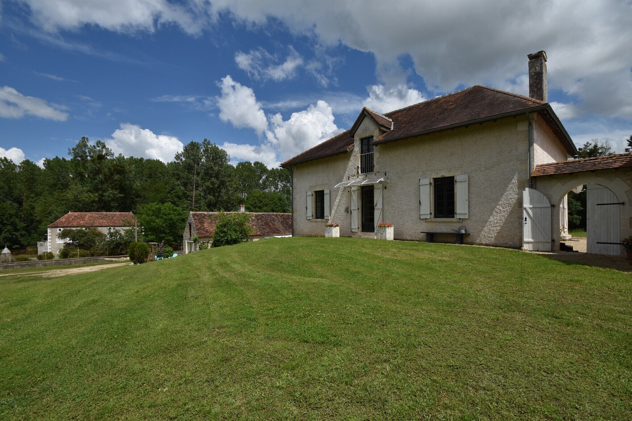 A two-story house with a sloped roof, a front porch, and a well-maintained lawn.