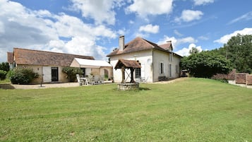 Il s’agit d’une propriété rurale dotée d’une grande pelouse, d’une maison traditionnelle avec un toit en tuiles et d’un bâtiment plus petit, également doté d’un toit similaire.