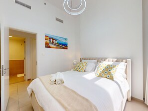 Une chambre d’hôtel avec un lit, un tableau et une porte donnant sur une salle de bain.