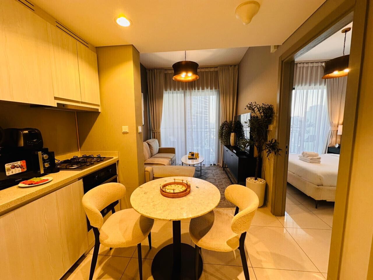 Un espace de vie compact comprenant une kitchenette, un coin repas et une chambre.