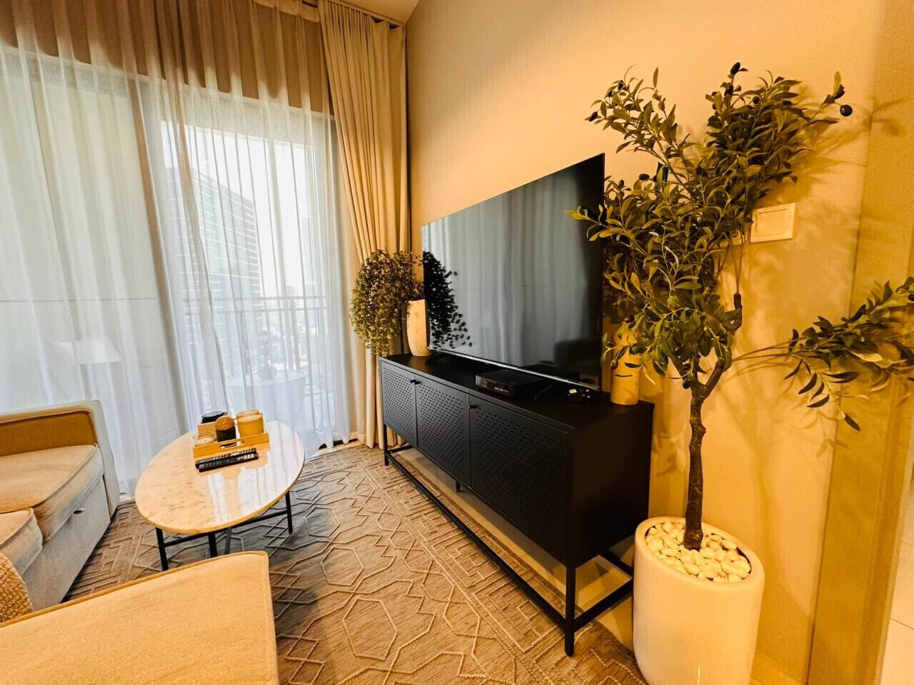 Un soggiorno moderno con un divano, un tavolino, una TV e un mobile.