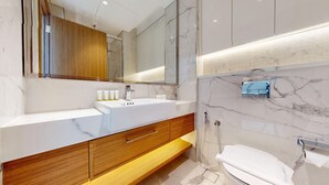 A modern bathroom with a marble vanity, wooden cabinet, and a large mirror. - Chic Studio | Premium Amenities | Fully Furnished (Dubai)