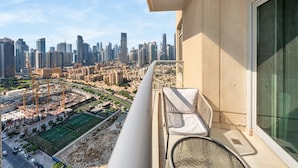 A balcony with a view of a cityscape, including high-rise buildings and construction cranes. - Luxury Downtown Living | 2BR | High Floor (Dubai)