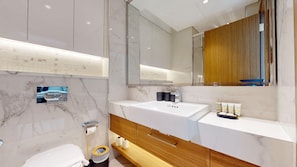 A modern bathroom with a large mirror, two sinks, and a wooden vanity. - Cozy Studio in Meydan | Premium Amenities (Dubai)