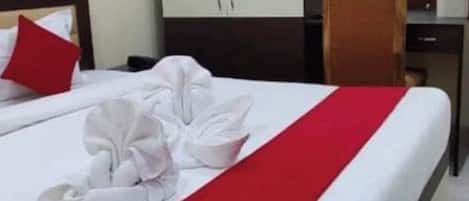 Habitación de hotel con cama bien hecha, un escritorio y una silla.