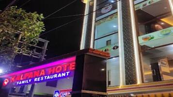 Un edificio con un cartel que dice 'Kalpana Hotel' y 'Inauguración del Patio de Comidas'.