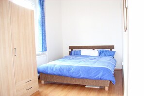 A bedroom with a bed, wooden wardrobe, and a window with curtains. - Apartment with Tatra Panorama View (Stary Smokovec)