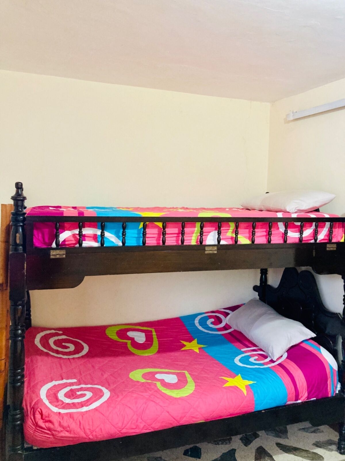 A bunk bed with a colorful bedspread and a white pillow.