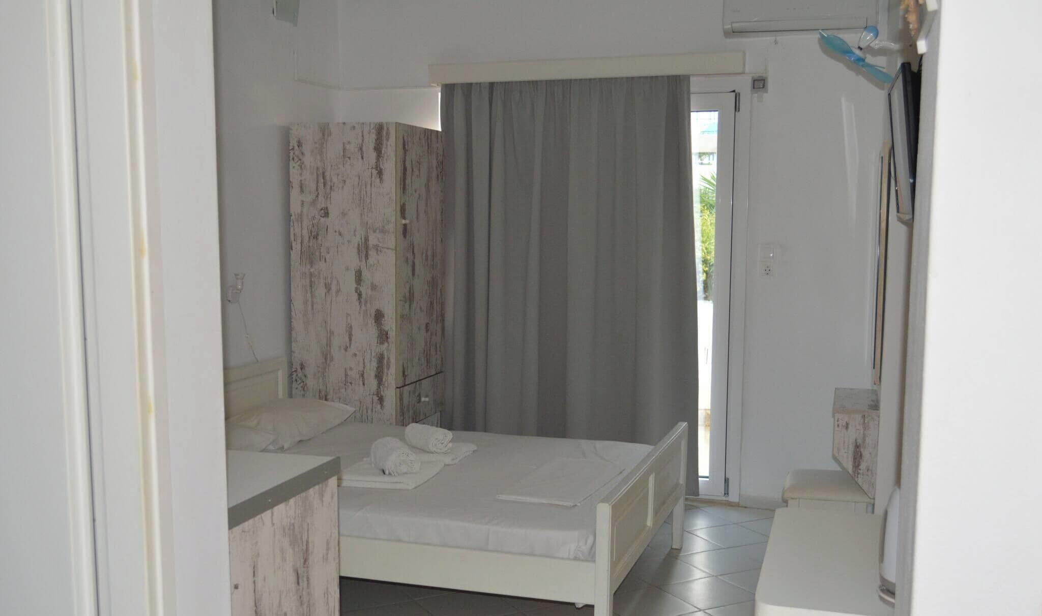 Una camera da letto con un letto, un comodino, un armadio e un bagno con doccia.