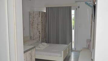 Una camera da letto con un letto, un comodino, un armadio e un bagno con doccia.
