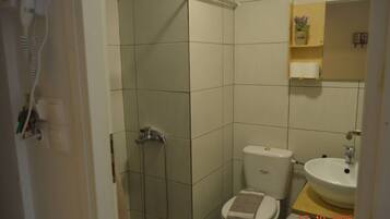 A bathroom with a shower, toilet, and sink.