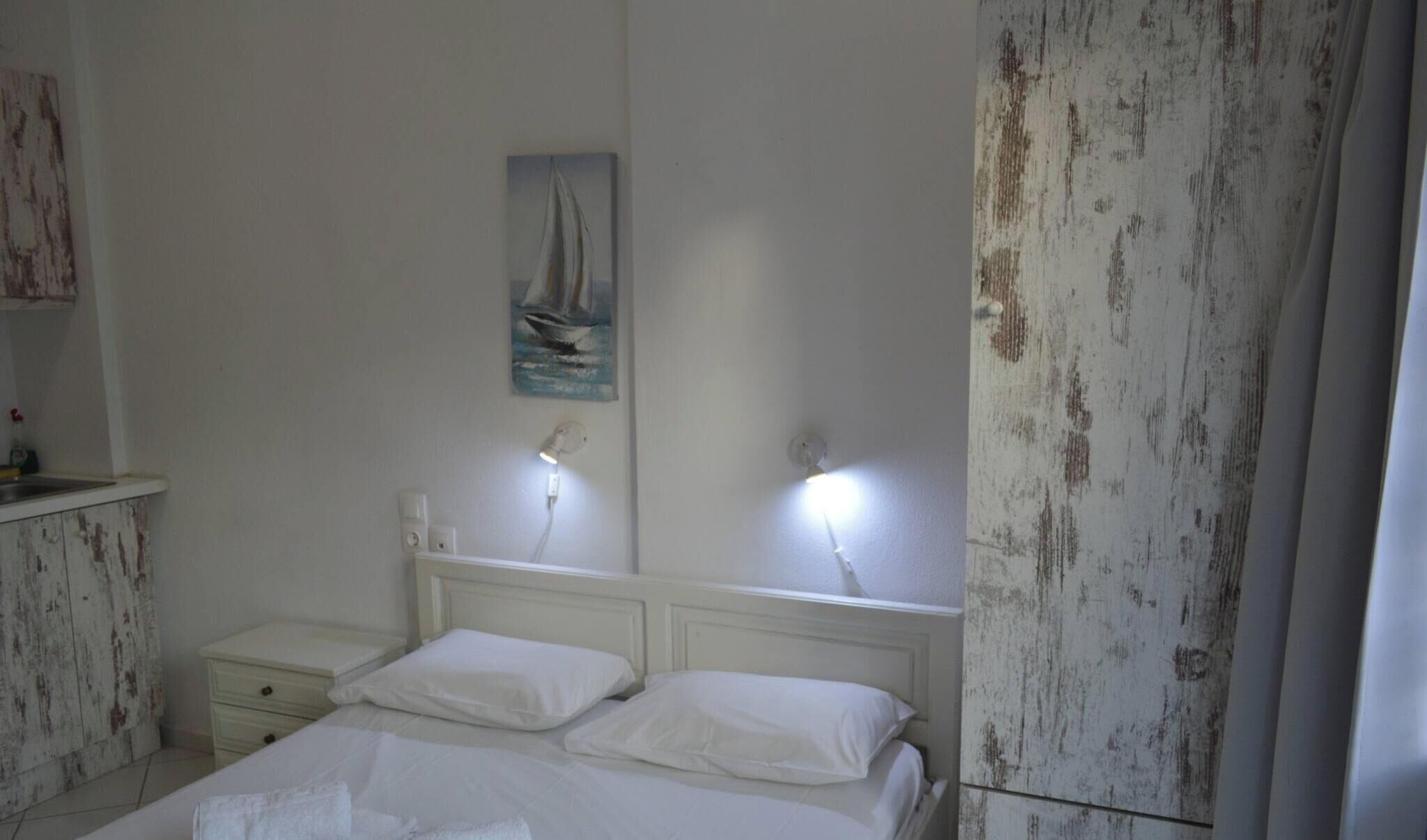 Una camera da letto con un letto, comodini, un quadro e una parete con finitura anticata.