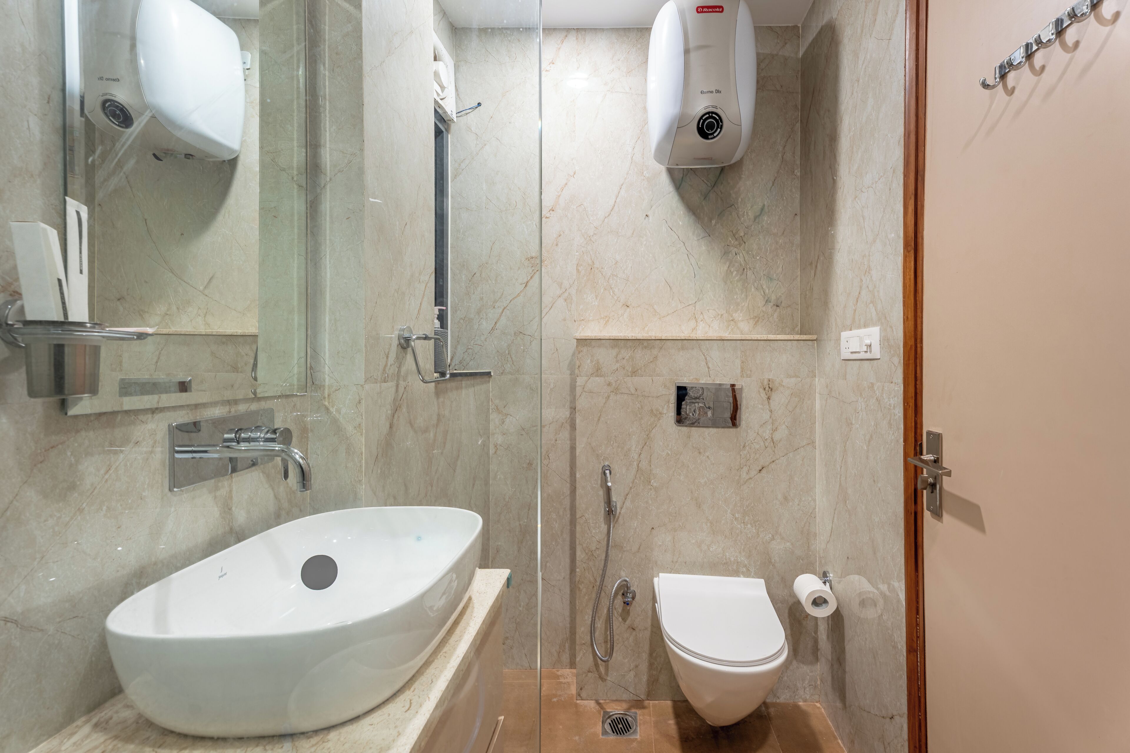 A bathroom with a white sink, toilet, and a glass-enclosed shower area.