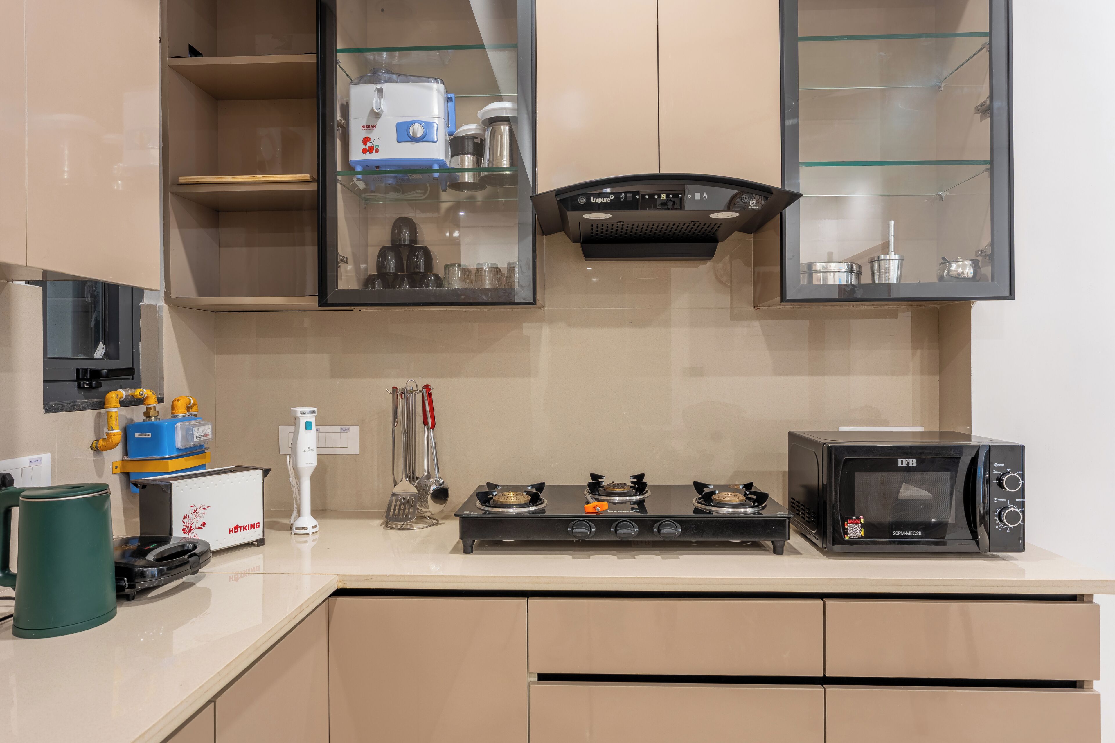 A modern kitchen with a gas stove, a microwave, and various kitchen appliances.