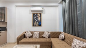 Ein Wohnzimmer mit einem braunen Sofa, einem мраморный Couchtisch und einer Wand-Klimaanlage.