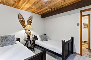 Une chambre avec deux lits simples, une petite table avec une lampe et un élément décoratif fixé au mur.