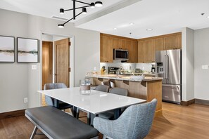 A modern kitchen with wooden cabinets, stainless steel appliances, and a central island. - Steps to Gondola • Shared Pool + Mountain Views • Resort Access | Gondola & Gold (Avon)