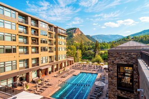 A hotel with a swimming pool, outdoor seating, and mountain views. - Ski Valet + Resort Pool + Hot Tubs | Valley Views | Riverfront Perch (Avon)