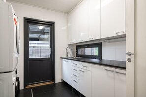 Eine kleine Küche mit Kühlschrank, Mikrowelle und Spüle.