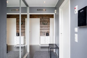 A reception area with a glass partition, a 'Welcome To Our Home' sign, a 'Keys' sign, and a bench. - Christmas 4BR Villa Private Sauna By Lapland Host (Rovaniemi)