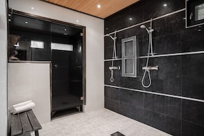 Ein modernes Badezimmer mit Dusche, Sitzbank und Toilette.