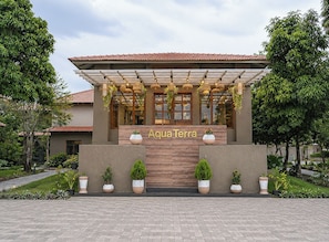 A building with a pergola entrance, potted plants, and the name 'Aqua Terra' displayed.