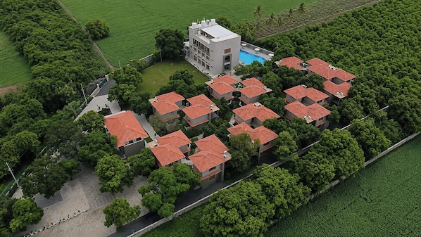 A residential area with multiple buildings, a swimming pool, and lush greenery.