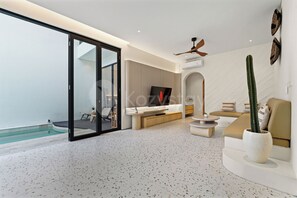 Ein modernes Wohnzimmer mit Glastür zu einem Pool, Deckenventilator und großem Fenster.