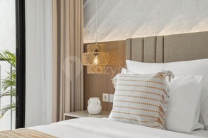 A hotel room with a bed, a nightstand, a lamp, and a view of the outdoors.