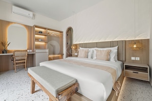 A modern bedroom with a large bed, bedside tables, a bench, a wardrobe, and a mirror.