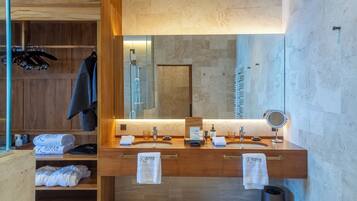 A modern bathroom with a wooden vanity, dual sinks, a large mirror, and a glass shower enclosure.