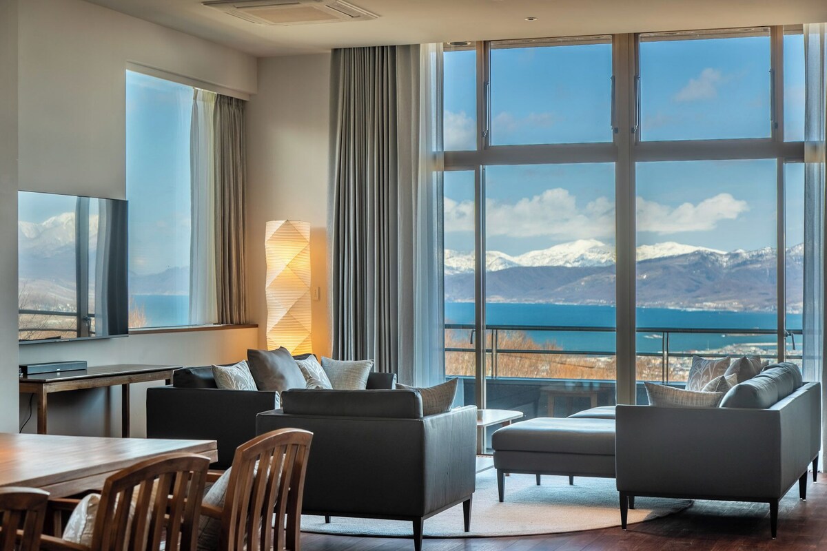 A modern living room with a large window offering a scenic mountain view.