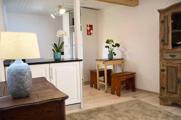 A room with a wooden table, two chairs, a lamp, and a cabinet.