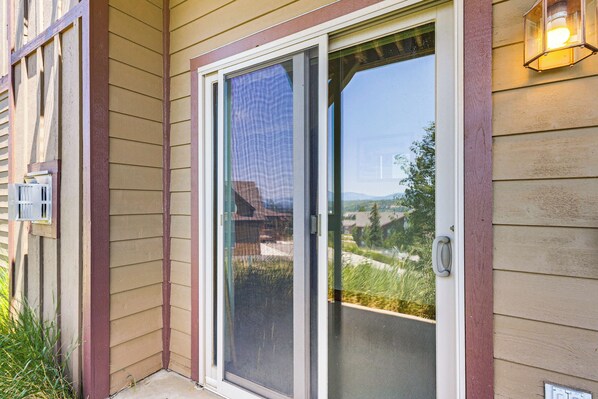 A sliding glass door with a view of a residential area. - Hike, Bike & Ski! Rendezvous Cabin w/ Mtn Views (Fraser)