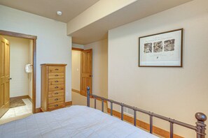 A bedroom with a bed, a dresser, a door, and a framed certificate on the wall. - Hike, Bike & Ski! Rendezvous Cabin w/ Mtn Views (Fraser)
