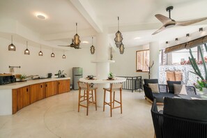 A modern kitchen with a central island, wooden cabinets, and pendant lighting. - Hillstone Luxury Villa 8 by Betterplace (Uluwatu)